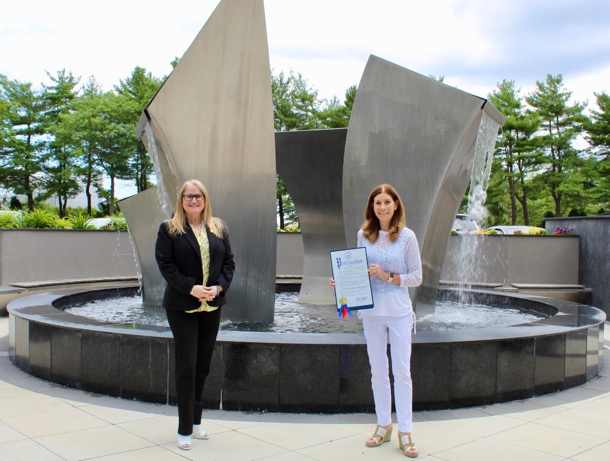 Suffolk Legislator Susan A. Berland (left) presents Linda Beigel Schulman a proclamation in honor of her being named the 16th Legislative District’s “Woman of Distinction.”