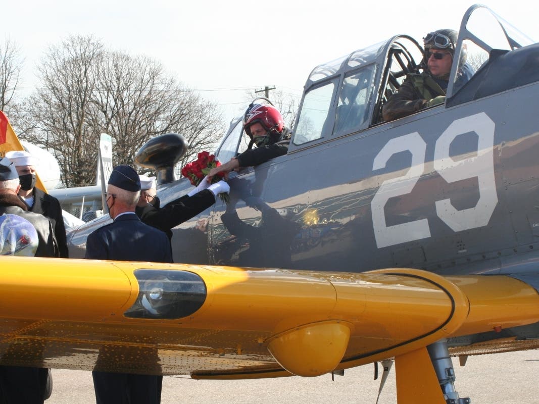 Blessed roses are delivered to a vintage AT-6 Texan Warbird at the "Dropping of the Roses" ceremony on Monday at the American Airpower Museum in Farmingdale.