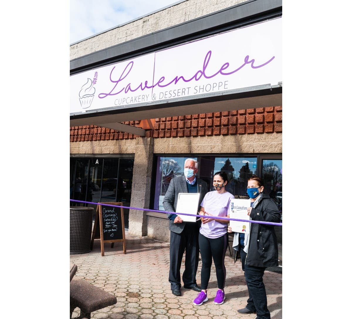 Sara Caiola (center) receives proclamations at Saturday's grand opening of Lavender Cupcakery in Hauppauge, a business she owns with her boyfriend, Tyler Indelicato.