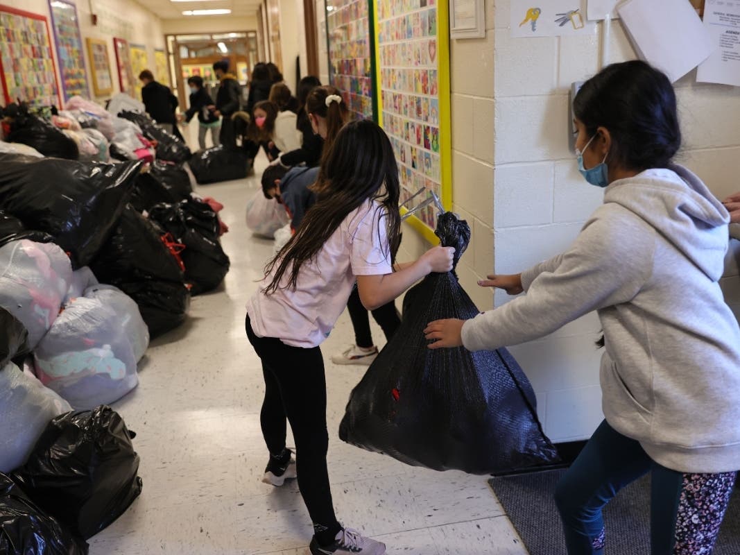 Students of Tackan Elementary School in Smithtown help load a truck filled with donated items.