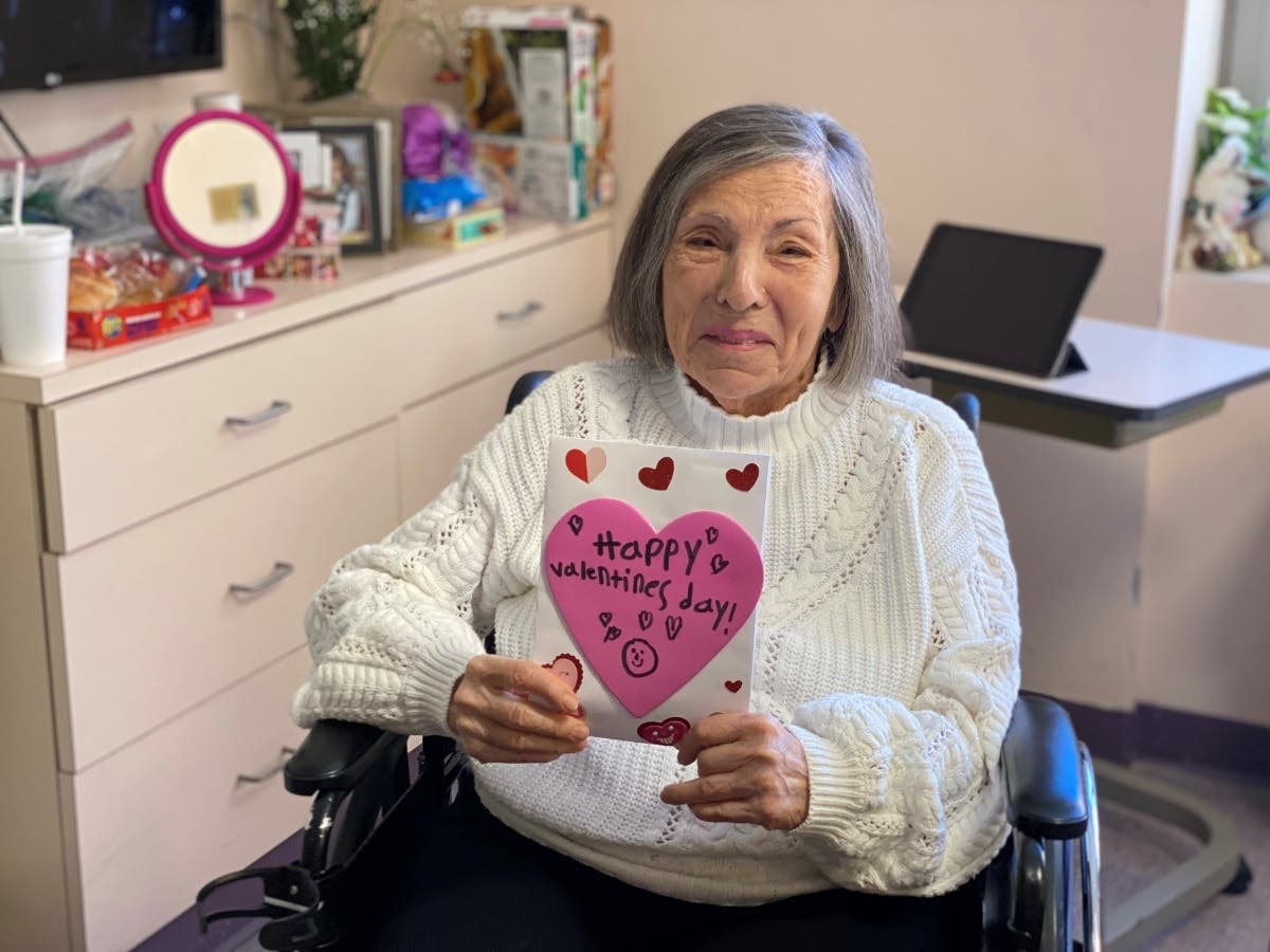 A woman at Commack's Gurwin Healthcare Nursing & Rehabilitation Center holds a Valentine's Day card she received from Islip's Suffolk County Girl Scout Service Unit #44 and students of Maud S Sherwood Elementary School.