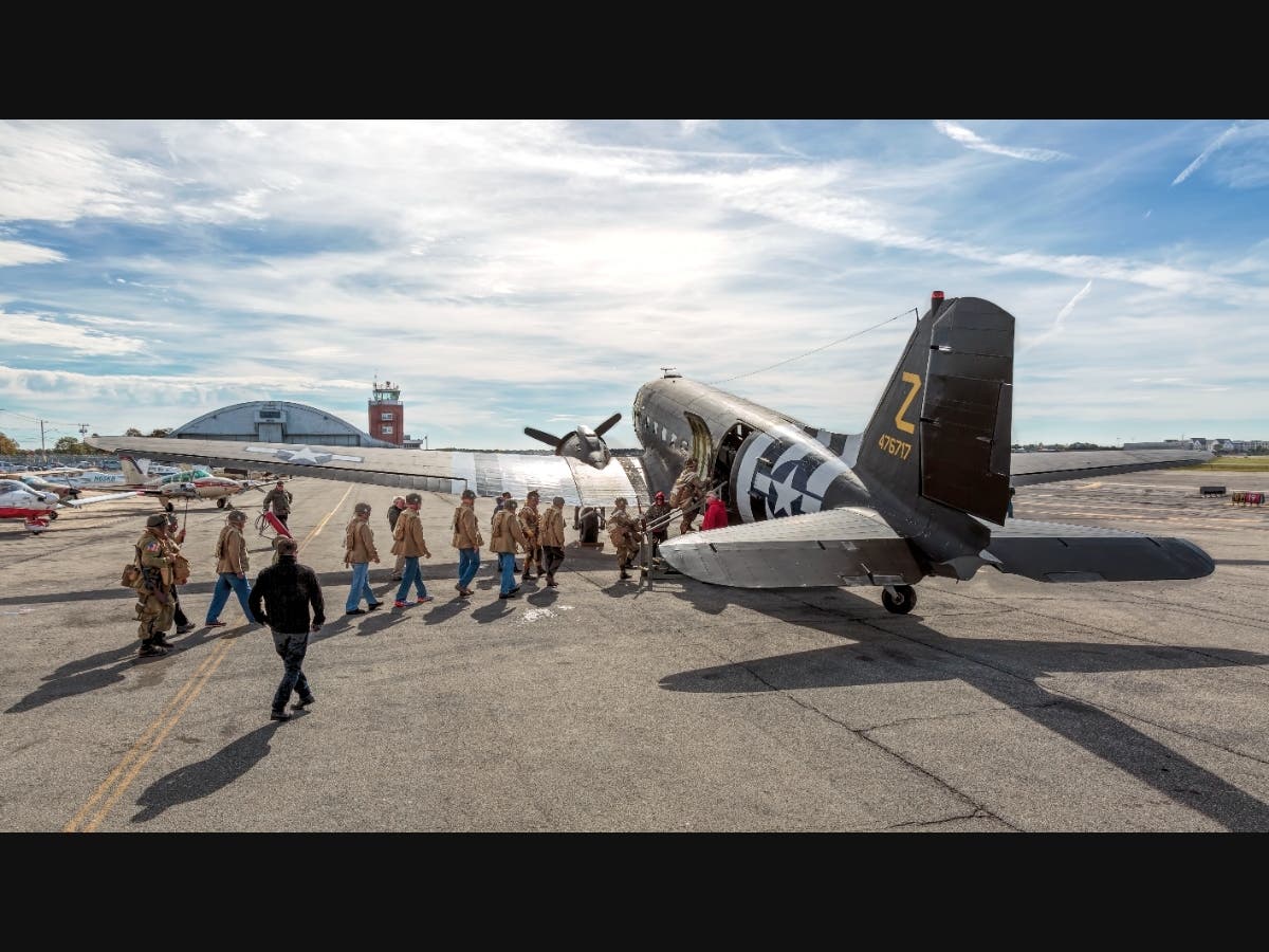 Living Historians and participants line up and board AAM’s WWII Douglas C-47B Skytrain Second Chance at the American Airpower Museum in Farmingdale.