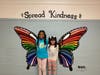 Oakwood students Keyana Lyons and Melanie Argueta try out the new mural at the school. The mural was painted by Whitman Art Honor Society members.