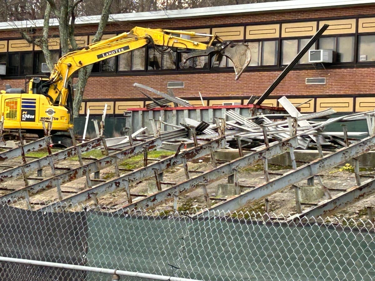 An excavator removes bleachers at Walt Whitman High School in South Huntington.
