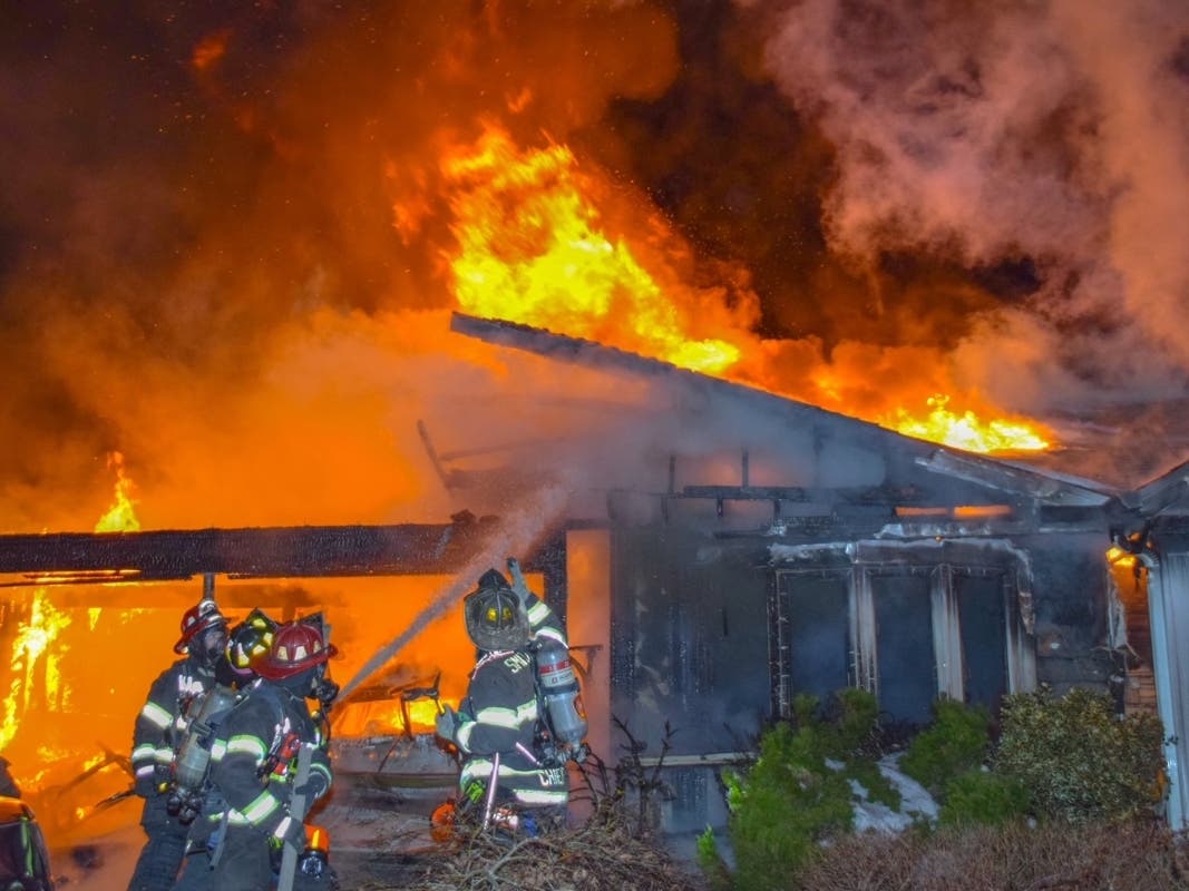 Firefighters battle a house blaze in Smithtown on Tuesday morning.