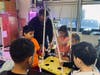 Third graders help Karavias make plant support stands.
