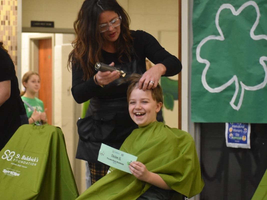 Pulaski Road student Declan smiles as he has his head shaved as a sign of solidarity with children battling cancer.