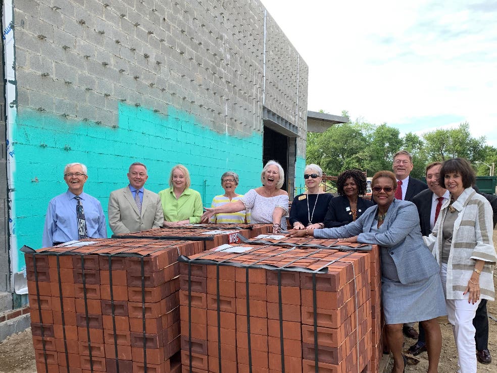 Anne Arundel County Public Library Foundation board members stand with bricks at the Annapolis library construction site