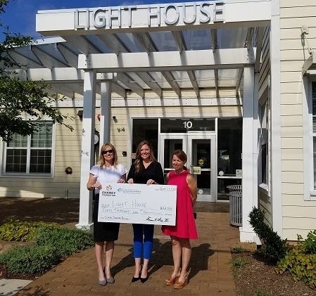 Vice Chair of The Chaney Foundation, Rebekah "R.G." Lare, far left, Light House Director of Development Jenny Crawford, middle, and Community Foundation of Anne Arundel County Manager, Grants & Scholarships Kristen Krall stand outside The Light House.