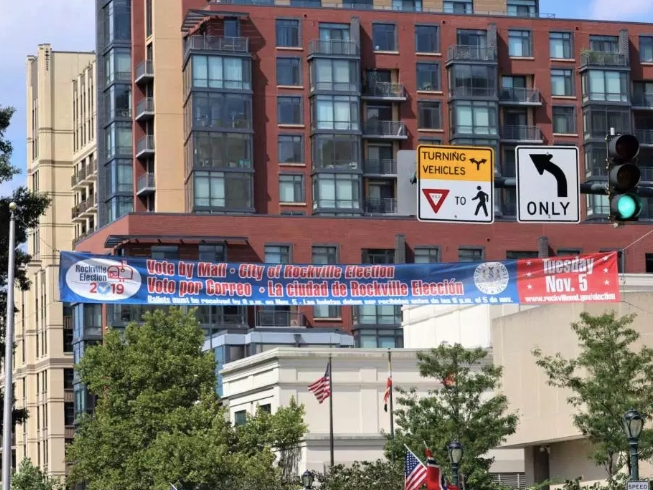 A banner hangs in Rockville Town Center to remind voters about the upcoming election, which will be conducted mostly by mail. 