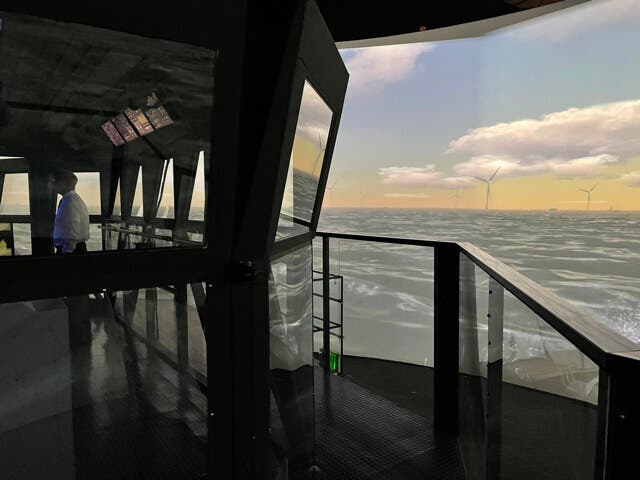 Computer-generated windmills are reflected off the bridge windows of a massive simulator at the Maritime Institute of Technology and Graduate Studies in Linthicum Heights.