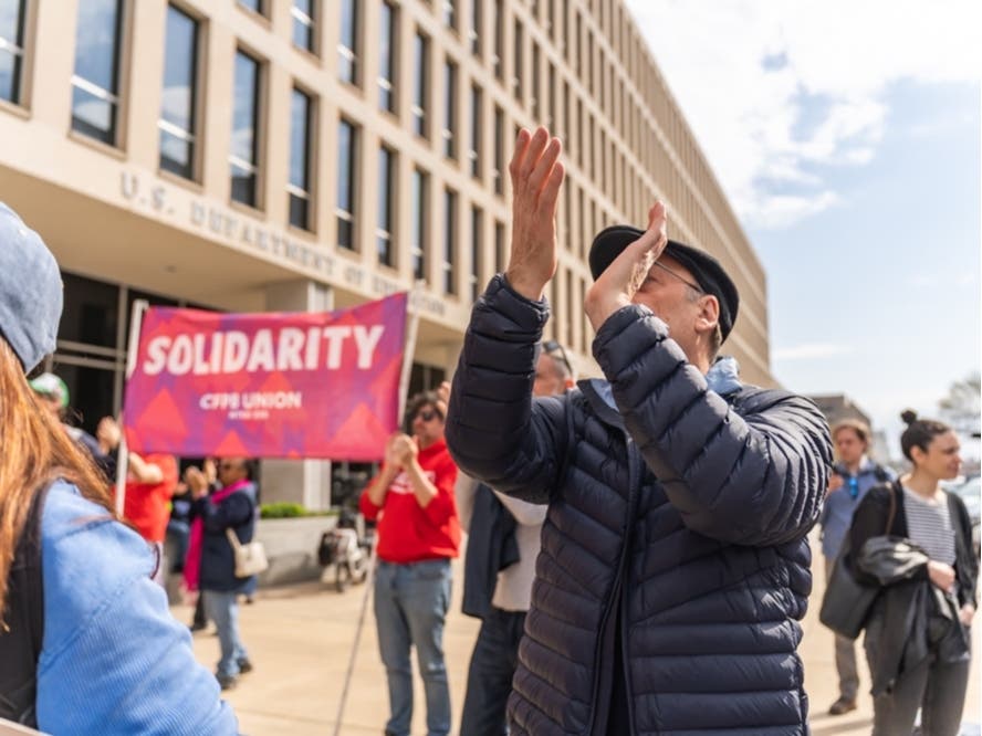 Bill Bimber claps for federal workers who have lost their jobs at the U.S. Department of Education in Washington, D.C. on March 28, 2025.