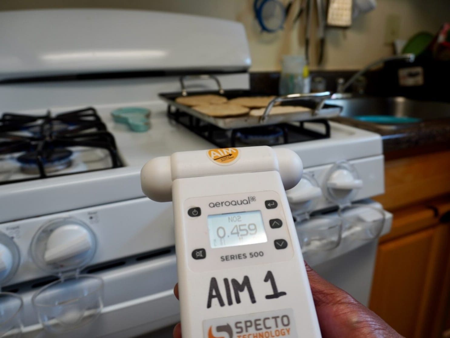 A resident of the Northwest Park Apartments uses a handheld nitrogen dioxide detector to assess from using a gas stove in their home. 