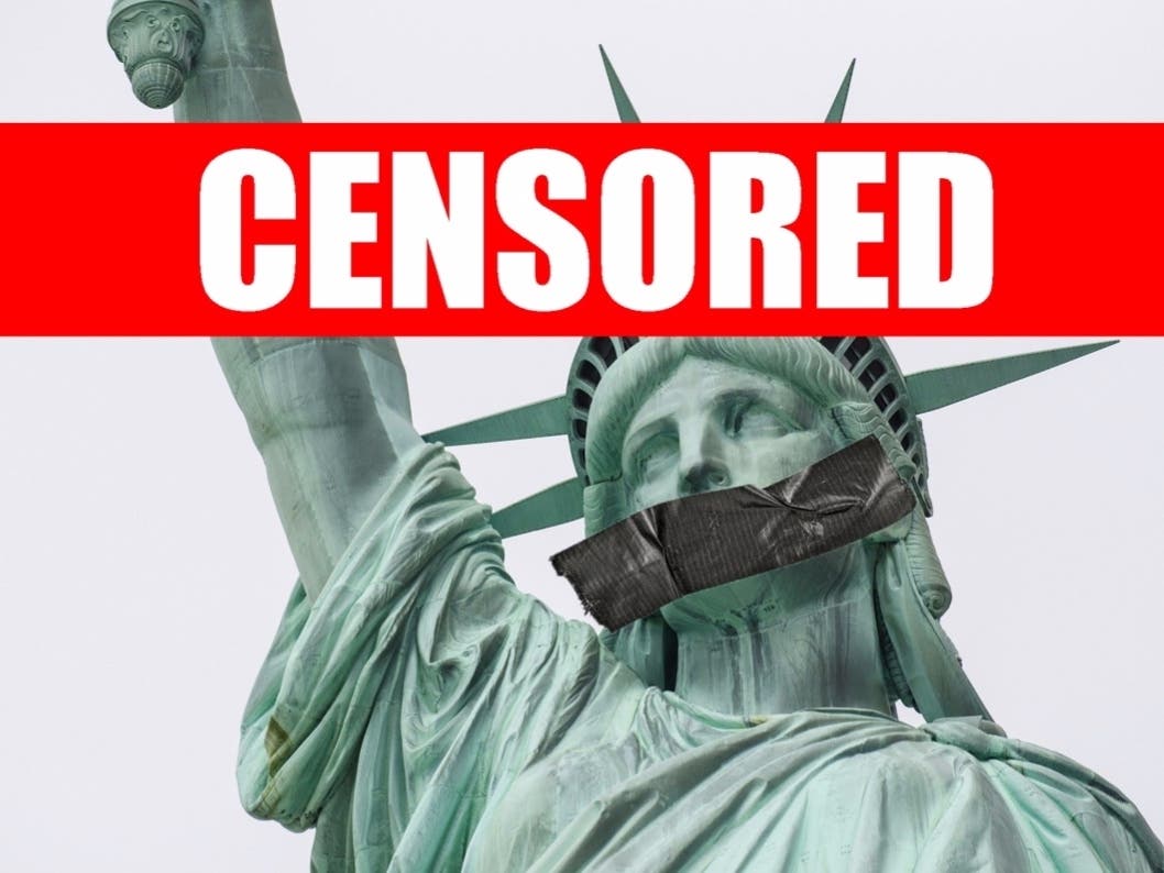 Statue of Liberty's head close-up with her mouth symbolically gagged representing censorship of freedom of speech.