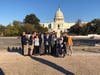 A handful of members in front of the U.S Capitol. 