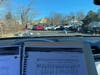 A Driveway Choir participant’s view from inside his car. Sheet music, a specially prepared microphone, and a car radio tuned to 107..1 allowed for singing as part of a larger group. Music Ministry Director Patricia Clark leads the event using a headset.