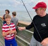 Lukas, 11, of Ocean View, holds a weakfish he helped reel in with Ocean City Fishing Club member Ross Seyfert yesterday
