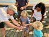 Ocean City Fishing Club member Tom Yucis lets Bode Weber, 3, (right) touch the kingfish he just caught, while his brother R.D. Weber, 4, and their grandmother Sue Lawver observe