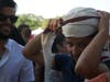 A man covers his head to cool off in the summer heat.