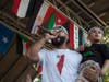 Waheeb Nasan, Palestinian American rapper, performs holding a Palestinian American boy who came from the crowd.