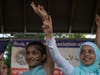 Children wave peace signs after they were invited onto the stage from the crowd.