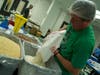 Ted Swartwood, regional manager for New York and New Jersey for the Outreach Program, poured grain into a container to set up an assembly line.
