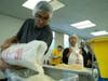 Members of the Brooklyn College Rotaract poured grain into a container to set up an assembly line.