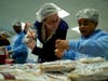 Kimberly Gail Price, left, president of the Brooklyn Bridge Rotary Club, works with a girl scout from Saint Gregory the Great Catholic Academy, right.