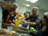 Members of the Brooklyn College Rotaract poured food through a funnel into a plastic bag. 
