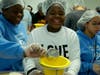 Girl scouts from Saint Gregory the Great Catholic Academy poured food through a funnel into a plastic bag. 