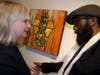 Artist Craig Anthony Miller, right, talked about his work hanging on the wall, “Heavy Momentum Ganesh.” 