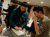 Gyatso Chuteng, an organizing committee member for Art for Tibet, right, worked with other volunteers to package the art each highest bidder won at the end of the auction. 