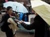 Nicole Izsak, right, a former Hong Kong resident, delivered flyers outlining the Uyghur struggle to conference attendees.