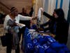 Nikita Mehta, Assistant District Attorney at the Brooklyn DA's Office Human Trafficking Unit, right, received from a woman, left, a plastic bag filled with donated goods for human trafficking survivors.