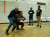 Derrick Strong, left, owner of Team Demolition Mixed Martial Arts gym, showed the crowd self-defense techniques on Jasmine Ray, director of Cornerstone Daycare Center. Strong described moves to fight off human traffickers. 