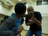 Derrick Strong, right, owner of Team Demolition Mixed Martial Arts gym, explained to 9-year-old, Carter Davis, left, how to box. Strong showed moves for kids to defend themselves against child traffickers. 