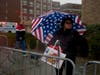 An onlooker, right, watched a group marching as part of the Chinese New Year parade. The group advocated freedom for Uyghurs being held in detention centers without due process in China.