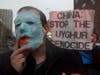 Fawad Faqeeri, a supporter of Uyghur human rights, wore a mask of the blue flag of East Turkestan. On the mask, a red painted hand of the Chinese flag covered the mouth. 