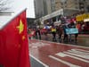 On Main Street, Flushing, dozens of Chinese flags lined both sides of the street as a group, right, that was part of the Chinese New Year parade marched for human rights for Uyghurs under the rule of the Chinese communist government in Xinjiang, China.
