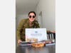 Pvt. Juliana, an IDF Lone Soldier from Los Angeles, with a snacks and sweets package delivered by FIDF.