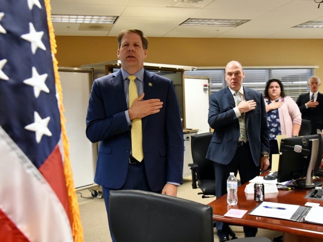 Gov. Chris Sununu is pledging allegiance to the flag at the start of a recent Executive Council meeting. He wa at the emergency operations center in Concord in this file photo.