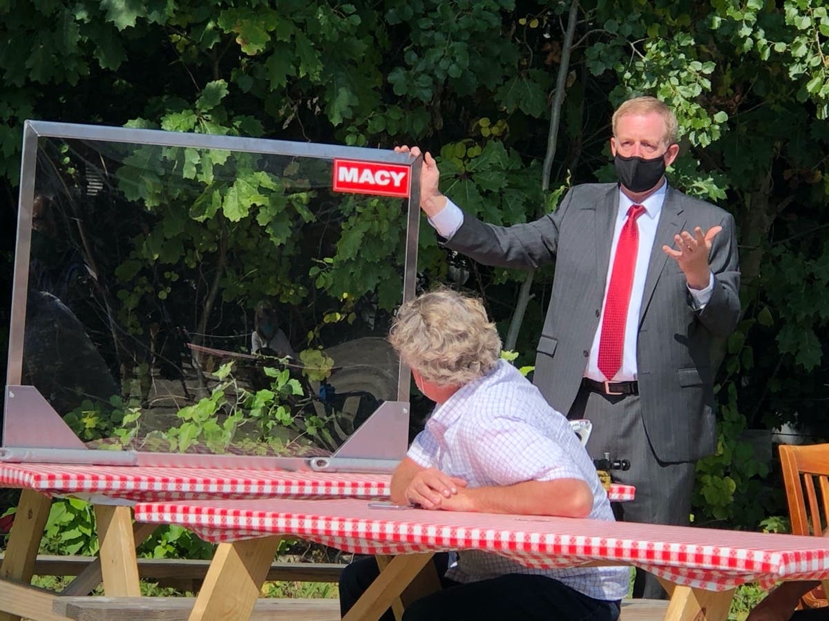 Mike Somers, chief executive officer of the New Hampshire Restaurant and Lodging Association, showcases what plexiglass dividers between tables would look like at roundtable at Newick’s in Dover. last month.