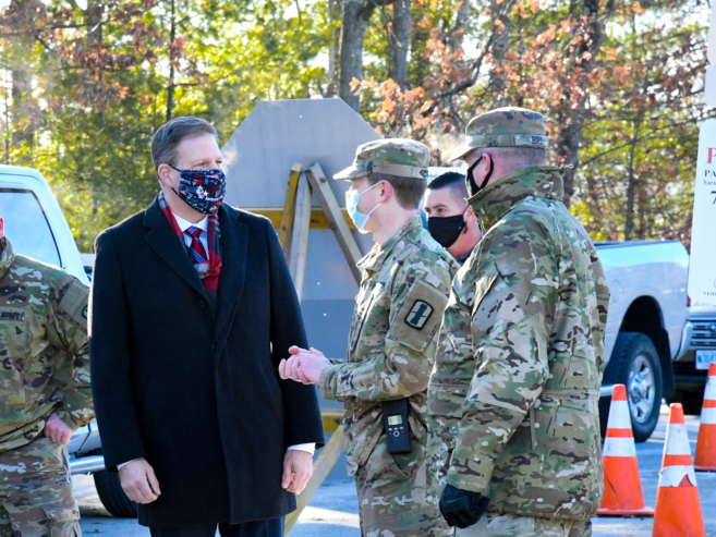 Gov. Chris Sununu is pictured talking with members of the National Guard at a Londonderry drive-through vaccination site on Tuesday.