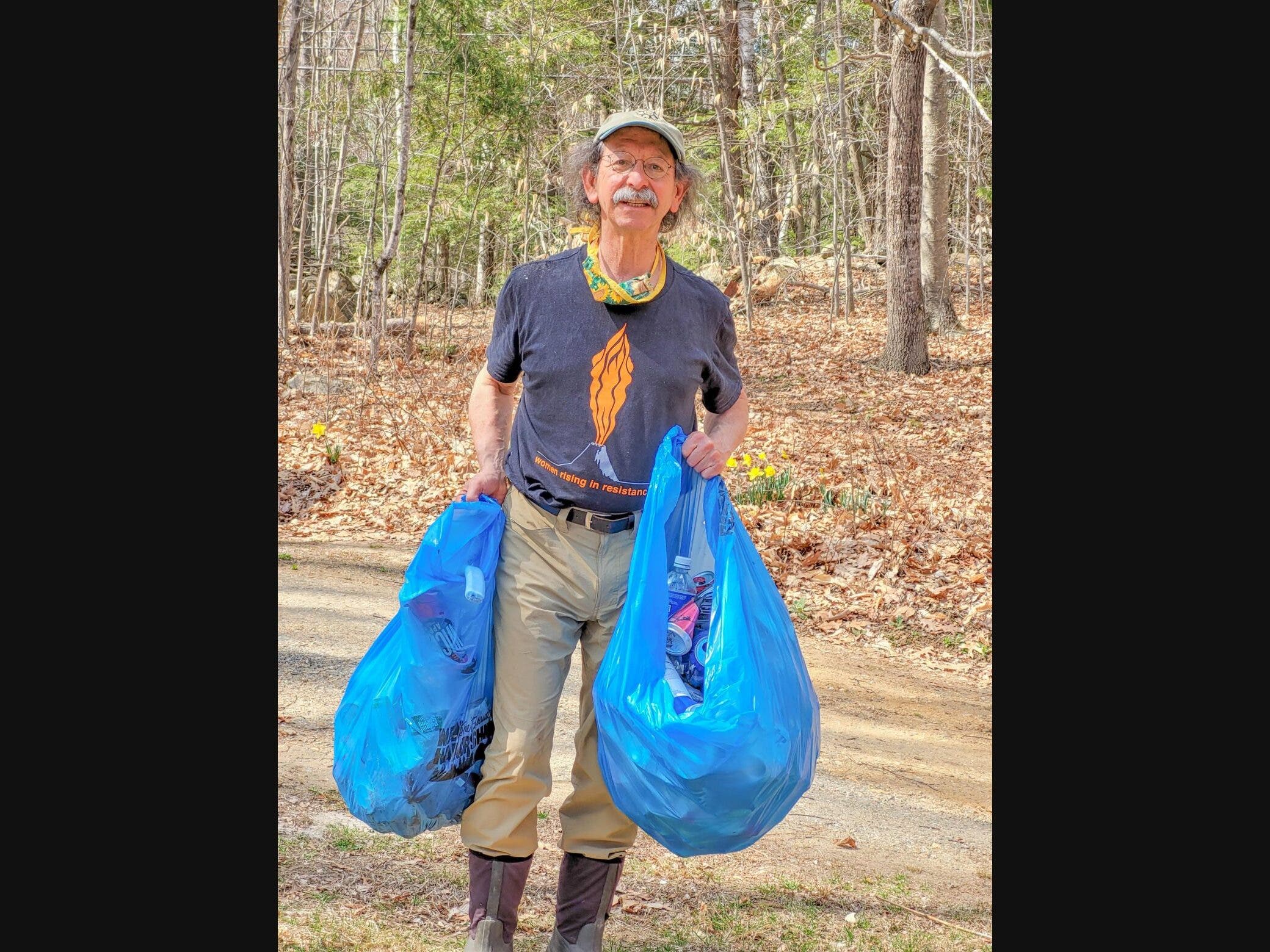 Arnie Alpert is pictured picking up roadside trash in Canterbury.