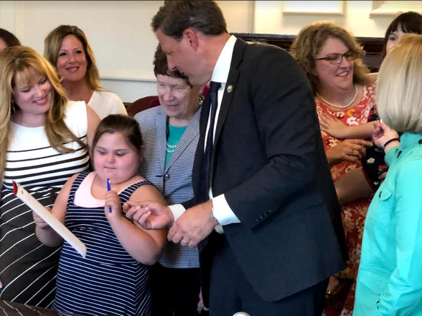 Gov. Chris Sununu signs legislation that will make it easier for parents to get the special education their children need with a little help from Katie Duran of Wolfeboro and her mother Carrie.