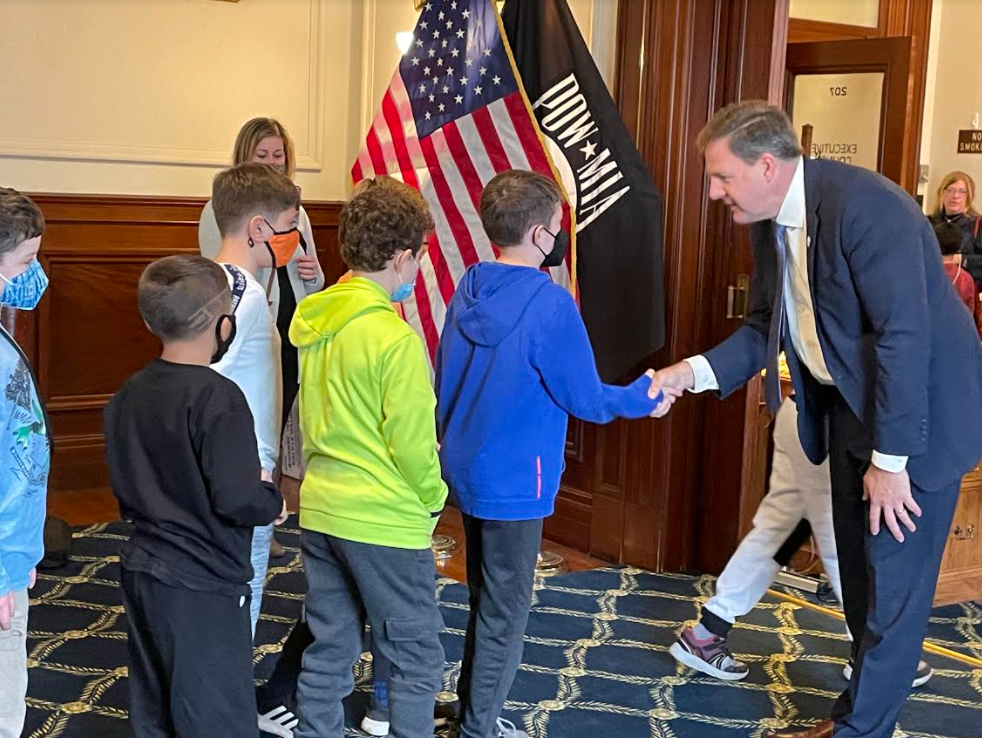 
 Gov. Chris Sununu is pictured shaking hands with a student tour group at the Executive Council meeting at the State House Monday.