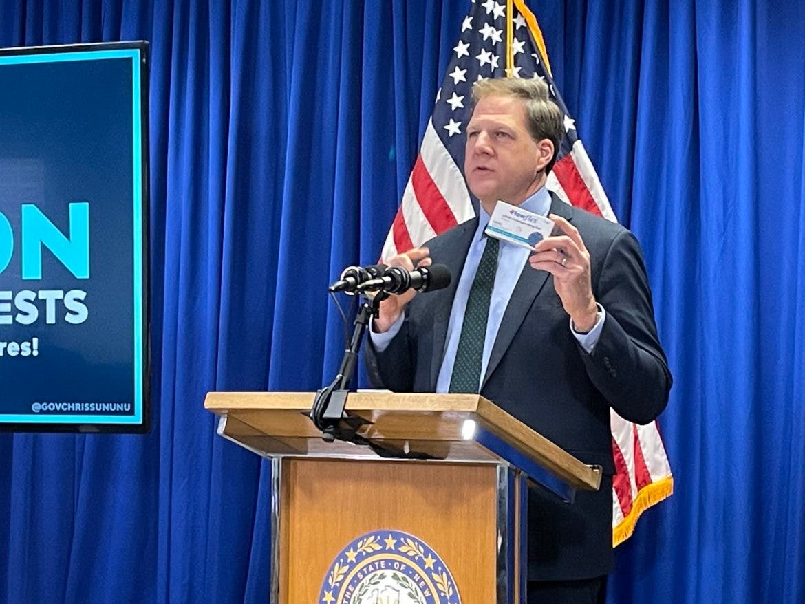 Gov. Chris Sununu holds test kits that will be sold at state liquor stores at cost in a couple of weeks at a press conference in Concord on Wednesday.