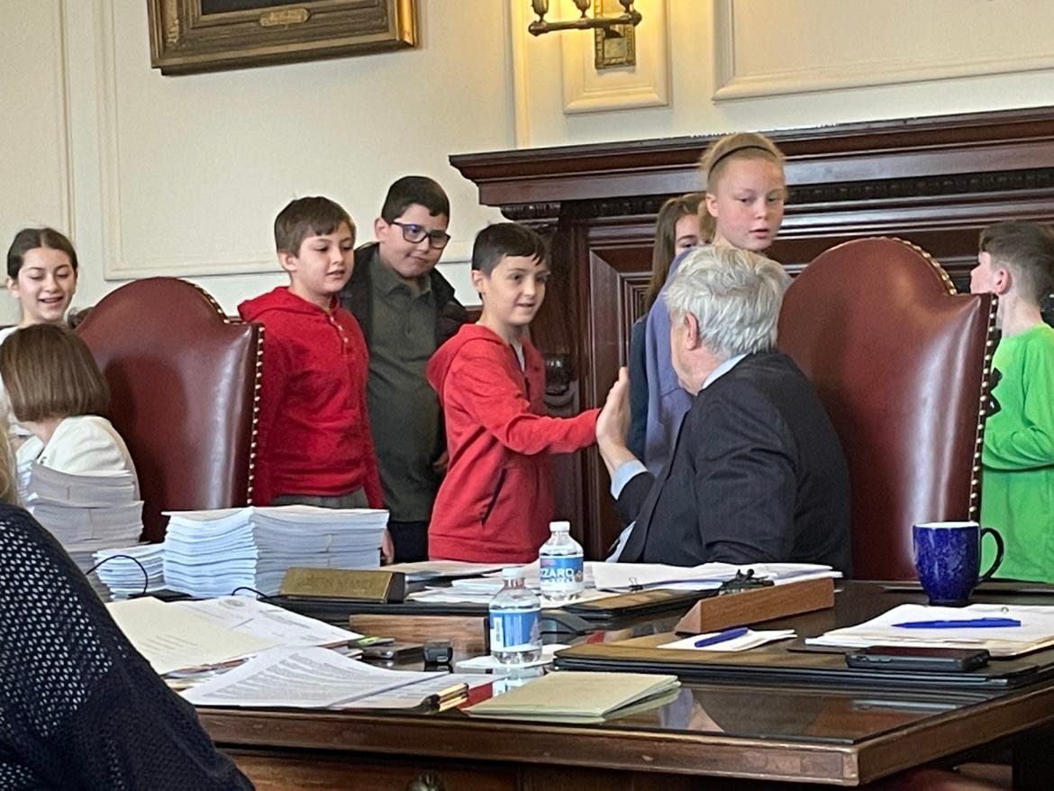 Executive Councilor Joe Kenney high-fives with students from Hooksett at Wednesday's meeting.