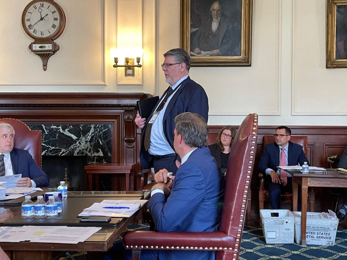 PUC Chairman Daniel Goldner is pictured speaking with Gov. Chris Sununu at Wednesday's Executive Council meeting. At left is Councilor Joe Kenney of Wakefield.