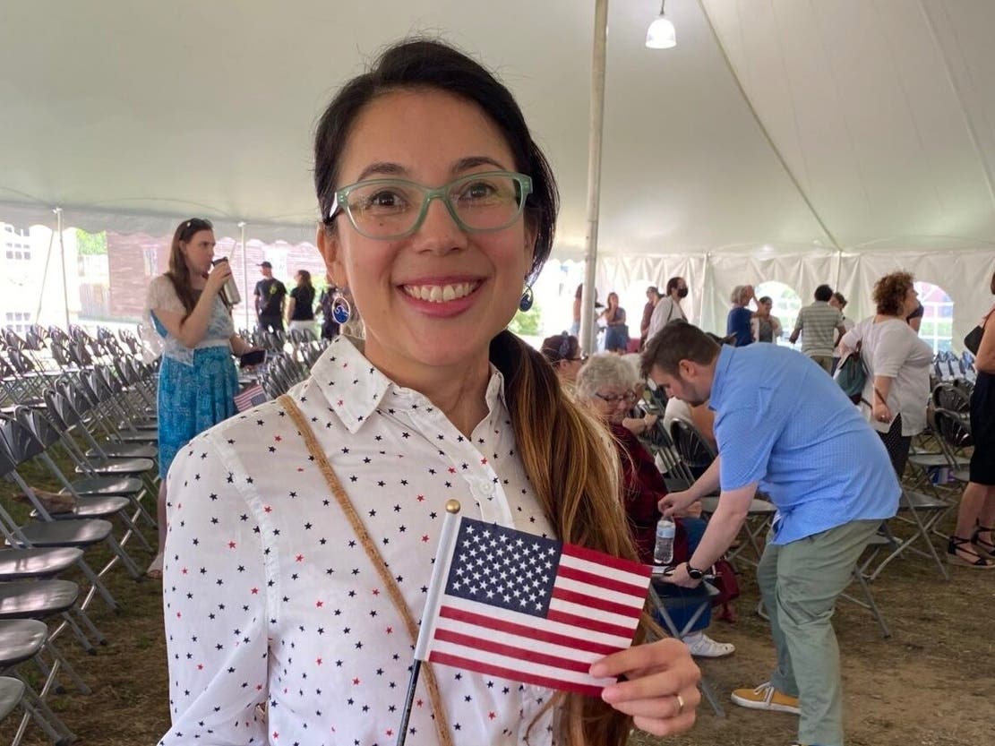 July Rubiano, new citizen from Colombia, poses with the American flag at the Naturalization Ceremony July 4, 2022, at Strawbery Banke in Portsmouth.